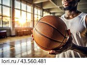 A black basketball player holds a basketball ball against the background of a basketball court. Hands and ball close-up. Стоковое AI-изображение, AI-художник Photojuli / Фотобанк Лори