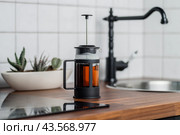French press in the kitchen. Teapot side view. The tradition of brewing black tea. Close-up photo. Стоковое фото, фотограф KOSIM / Фотобанк Лори