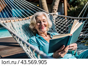 An elderly pensioner, a modern grandmother with glasses, reads a book on vacation in a hammock by the sea in natural light. Стоковое AI-изображение, AI-художник Photojuli / Фотобанк Лори