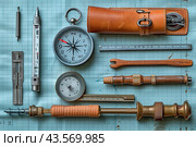 Assortment of Vintage Tools and Instruments on a Blue Gridded Surface. Стоковое AI-изображение, AI-художник Сергей Толмачёв / Фотобанк Лори