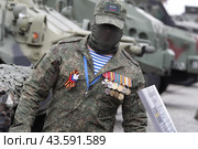 Москва военный в орденах на выставке подбитой военной техники во время проведения СВО на Украине (2024 год). Редакционное фото, фотограф Дмитрий Неумоин / Фотобанк Лори