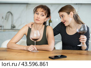 Sad woman sits silently in kitchen, friend sympathize and comfort her. Стоковое фото, фотограф Яков Филимонов / Фотобанк Лори
