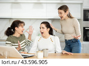 Three happy middle-aged woman expressing joy for winning in the kitchen. Стоковое фото, фотограф Яков Филимонов / Фотобанк Лори