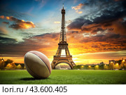 American football. A rugby ball on the background of the Eiffel Tower. The concept of sports games and competitions. The Summer Olympic Games. Стоковое AI-изображение, AI-художник Photojuli / Фотобанк Лори