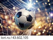 Goal. A soccer ball in the goal net, against a background of sparkling lights and a blurred background. Стоковое AI-изображение, AI-художник Photojuli / Фотобанк Лори