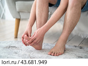 Foot pain, corns and calluses, dry skin on legs, man suffering from feet ache, podiatry concept. Стоковое фото, фотограф Станислав Тарко / Фотобанк Лори