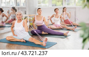 Elderly woman using figure eight resistance band for exercise in fitness class. Стоковое фото, фотограф Яков Филимонов / Фотобанк Лори