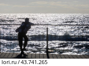 Человек смотрит на морские волны во время отдыха на курорте во время заката. Стоковое фото, фотограф Николай Винокуров / Фотобанк Лори