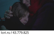 Grandmother hugs a little girl in a bomb shelter. Стоковое видео, видеограф Илья Шаматура / Фотобанк Лори