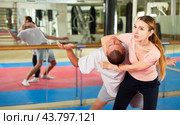Young woman practicing inverted facelock on male opponent in gym. Стоковое фото, фотограф Яков Филимонов / Фотобанк Лори