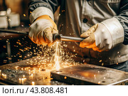 Work at the factory. Working professions. Men's hands in protective gloves with metal. There are sparks around. Hard work that requires high concentration and professionalism. Стоковое AI-изображение, AI-художник Photojuli / Фотобанк Лори