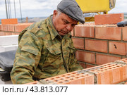 Каменщик работает на строительстве высотного дома (2008 год). Редакционное фото, фотограф Сергей Буторин / Фотобанк Лори