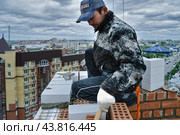 Каменщик работает на строительстве высотного дома (2008 год). Редакционное фото, фотограф Сергей Буторин / Фотобанк Лори