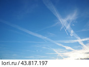Chemtrail conspiracy theory. Long-lasting condensation trails left in sky by high-flying aircraft are actually chemtrails consisting of chemical or biological agents, sprayed for nefarious purposes. Стоковое фото, фотограф Юлия Петровская / Фотобанк Лори