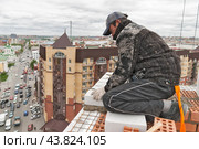 Каменщик работает на строительстве высотного дома (2008 год). Редакционное фото, фотограф Сергей Буторин / Фотобанк Лори