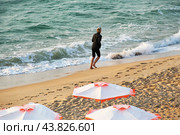 Утренняя пробежка вдоль моря. Молодая стройная женщина бежит вдоль линии прибоя по мокрому песку солнечным летним утром.  Morning run along the sea. Young slim woman runs along the surf line on the wet sand on a sunny summer morning. Стоковое фото, фотограф Лариса Гордеева / Фотобанк Лори