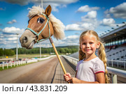 Hobbyhorsing. A new kind of sport. A stick with a horse's head to simulate a horse race. A girl at a horse racing stadium. Стоковое AI-изображение, AI-художник Photojuli / Фотобанк Лори