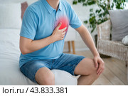 Heart attack, man with chest pain suffering at home, myocardial infarction. Стоковое фото, фотограф Станислав Тарко / Фотобанк Лори