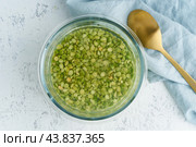 Soaking green peas cereal in water to ferment cereals and neutralize phytic acid. Стоковое фото, фотограф Natalia Gdovskaia / Фотобанк Лори