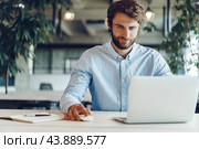 Businessman in shirt working on his laptop in an office. Стоковое фото, фотограф Сергей Толмачёв / Фотобанк Лори