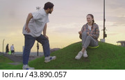 Man in the park extends his hand to a young woman, but she declines to shake it. Стоковое видео, видеограф Strunov David / Фотобанк Лори