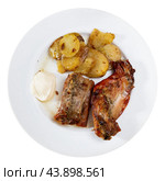 Lunch is served on plate - pieces of young rabbit cooked with segments of potato. Close-up. Стоковое фото, фотограф Яков Филимонов / Фотобанк Лори
