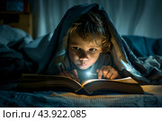 Мальчик не спит, тайком читает ночью интересную книгу под одеялом с фонариком. Стоковое AI-изображение, AI-художник Щеголева Ольга / Фотобанк Лори