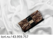 Black lacquer bag inlaid with diamonds lying on a white silk. Стоковое фото, фотограф Александр Собко / Фотобанк Лори
