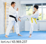 Underage boy and middle-aged man performing karate techniques in pair. Стоковое фото, фотограф Яков Филимонов / Фотобанк Лори