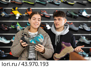 Couple examine view several item of winter comfortable trecking shoes. Стоковое фото, фотограф Яков Филимонов / Фотобанк Лори