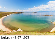 Baikal Lake in summer. Landscape of sandy beach on Olkhon Island near Kharantsy village on sunny day of August. Shallow warm bay on Small Sea and small island called Crocodile. Natural sea background. Стоковое фото, фотограф Виктория Катьянова / Фотобанк Лори