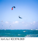 Kiteboarding. Fun in the ocean. Extreme Sport Kitesurfing. Kitesurfer jumping high in the air performing triks during kitesurfing session. Стоковое фото, фотограф Matej Kastelic / Фотобанк Лори