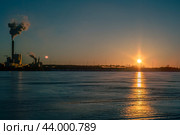 Joutseno, Finland - March 5, 2024: The paper factory in production during a clear evening weather in winter season. Silhouette of the building can be seen with the smoke coming from the pipe. Стоковое фото, фотограф Евгений Тарасенко / Фотобанк Лори