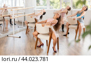 Young female instructor performing sass dance with chair during group class. Стоковое фото, фотограф Яков Филимонов / Фотобанк Лори