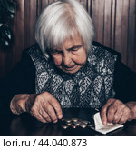 Portrait of an old woman counting money. The concept of old age, poverty, austerity. Стоковое фото, фотограф Matej Kastelic / Фотобанк Лори