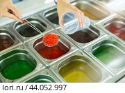 Hands scooping red bubble tea pearls into plastic cup. Стоковое фото, фотограф Яков Филимонов / Фотобанк Лори