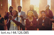 Gospel choir singing and clapping while performing in a church. Стоковое AI-видео, аниматор Данил Руденко / Фотобанк Лори