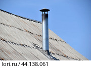 Silver stove pipe in the house against the blue sky. Стоковое фото, фотограф Valeriy Lushchikov / Фотобанк Лори