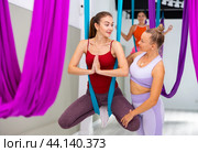 Woman practicing antigravity yoga with personal trainer. Стоковое фото, фотограф Яков Филимонов / Фотобанк Лори