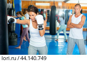 Asian woman training with punchbag. Стоковое фото, фотограф Яков Филимонов / Фотобанк Лори