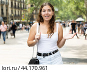 In pedestrian zone of historic European city stand suprised female tourist girl. Стоковое фото, фотограф Яков Филимонов / Фотобанк Лори
