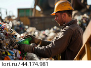 Worker sorting recyclables at waste management facility. Стоковое AI-изображение, AI-художник Иван Рябоконь / Фотобанк Лори