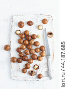 Plate with almonds in endocarp, whole and chopped open nuts in bulk on a cutting board. Стоковое фото, фотограф Natalia Gdovskaia / Фотобанк Лори