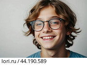 Portrait of a happy Caucasian schoolboy teenager with glasses on a solid gray background. Back to school, correction of pupil kid eyesight. AI generated. Стоковое AI-изображение, AI-художник Ольга Симонова / Фотобанк Лори