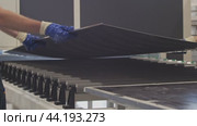 Two workers removed a metal sheet from the conveyor belt in order to inspect it for any defects. Стоковое видео, видеограф Strunov David / Фотобанк Лори
