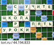 Буквы в игре "Скрабл" сложены в слова "скоро", "школа", "учите", "уроки", "мы", "пять", "ура" (2024 год). Редакционное фото, фотограф Ольга Дерябина / Фотобанк Лори