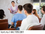 Female student talking about study topic with groupmates in auditorium. Стоковое фото, фотограф Яков Филимонов / Фотобанк Лори