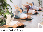 People lying on karemat, pulled bent legs to themselves and clamped soft-ball in knee. Стоковое фото, фотограф Яков Филимонов / Фотобанк Лори