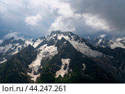 View of the Dzhuguturluchat mountain range of the Great Caucasus Range from the upper station of the cable car of the Dombay ski resort on a summer day, Karachay-Cherkessia, Russia. Стоковое фото, фотограф Ula Ulachka / Фотобанк Лори