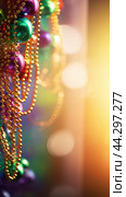 Colorful Mardi Gras beads and bokeh lights festive background. Стоковое AI-изображение, AI-художник Анастасия Золотницкая / Фотобанк Лори